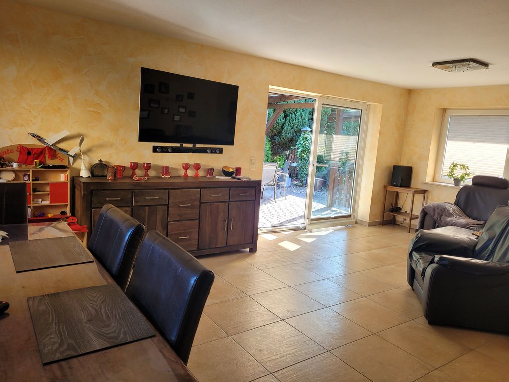 Blick ins Wohnzimmer mit Couchecke, Essplatz und Zugang zur Terrasse