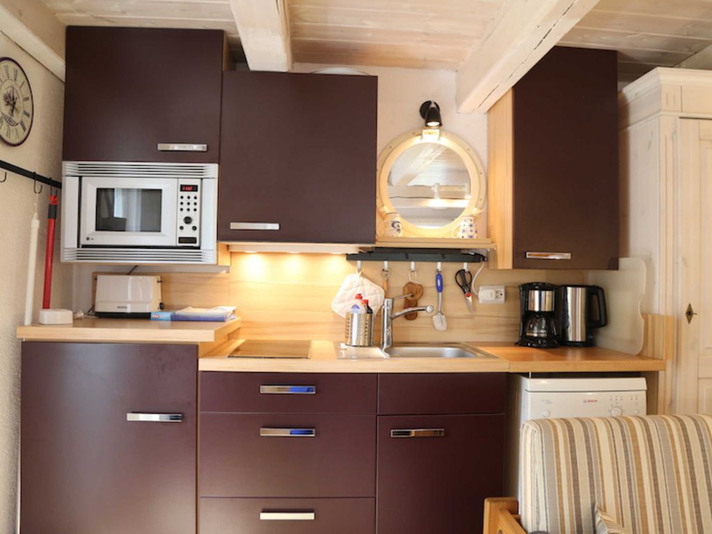 Die integrierte Küche hat einen Kühlschrank, Spülmaschine, 2 Platten Herd, Mikrowlle und Kaffemaschine.