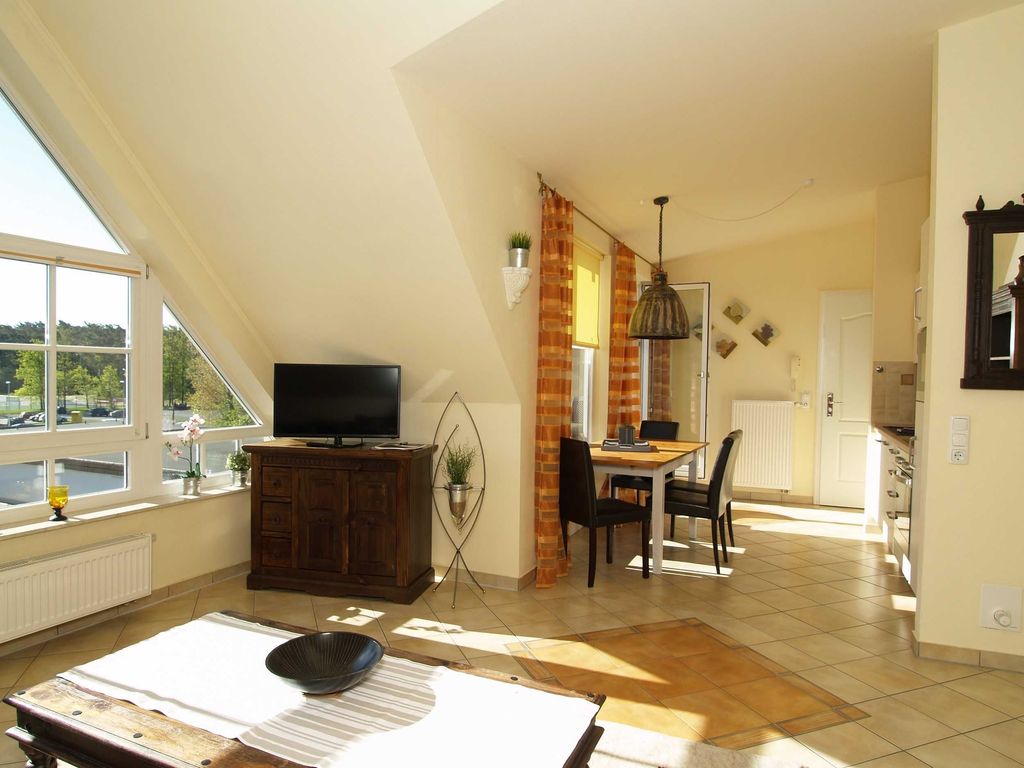 Der Wohnbereich mit Sitzecke und Flachbild-TV, Essecke und Zugang zum möblierten Balkon