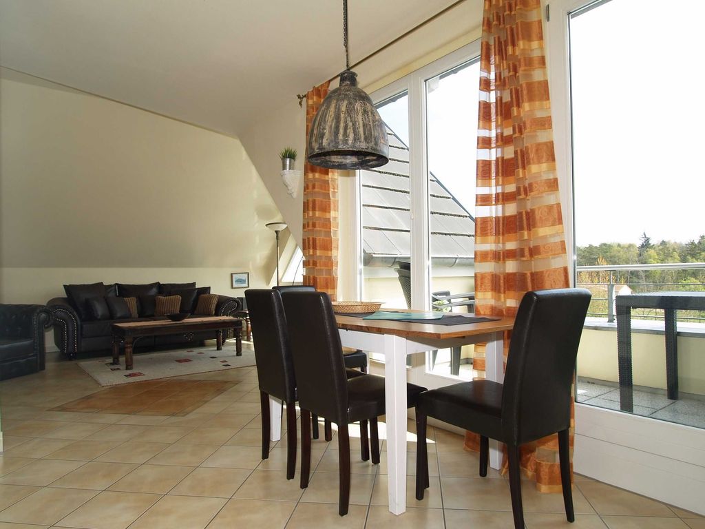Der Wohnbereich mit Sitzecke, Essecke und Zugang zum möblierten Balkon