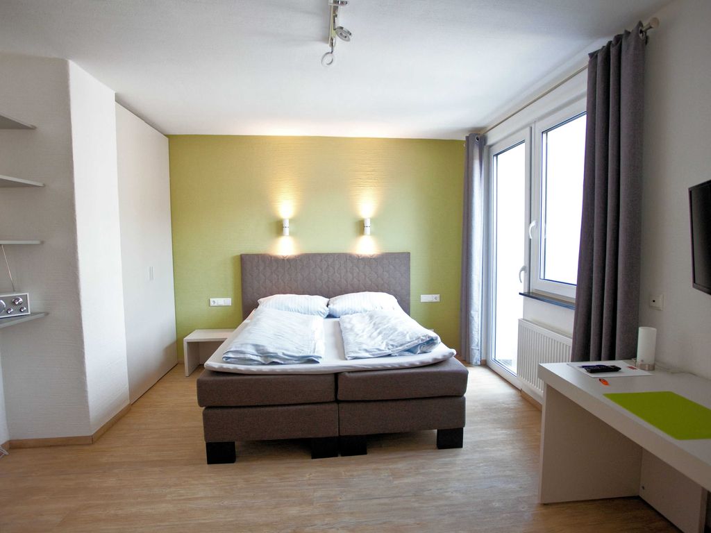 Boxspringbett und Zugang zum Balkon