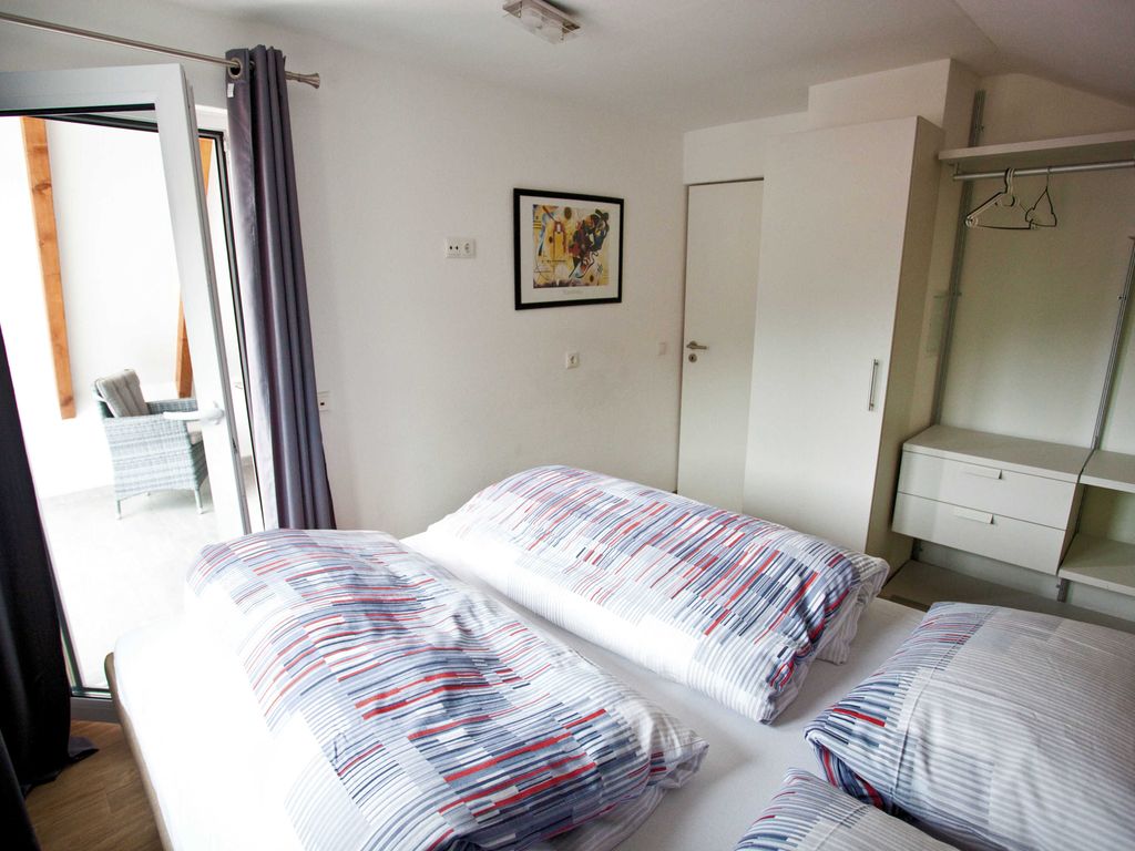 Schlafzimmer mit Boxspringbett und Zugang zur Loggia