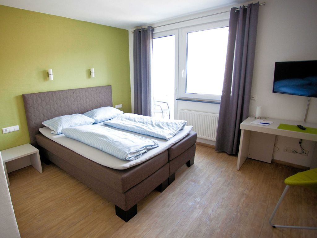Boxspringbett, TV und Zugang zum Balkon