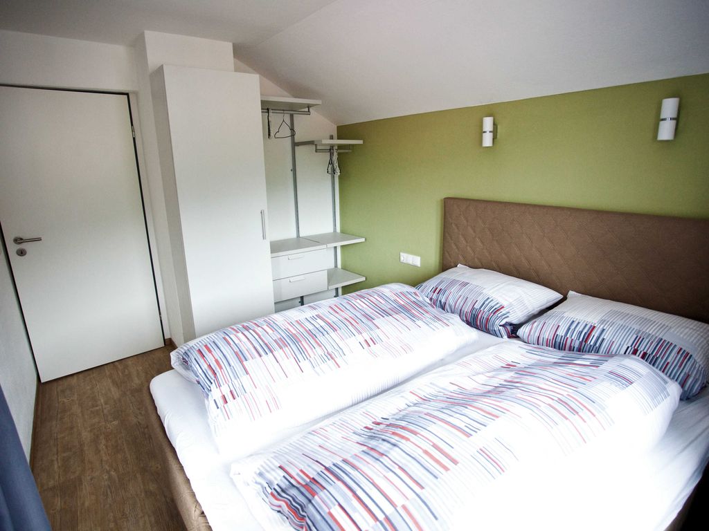 Schlafzimmer mit Boxspringbett und Zugang zur Loggia