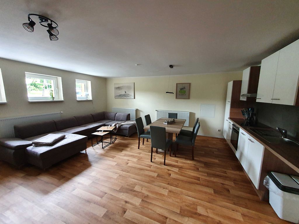 Offenes Wohnzimmer mit Einbauküche und Esstisch