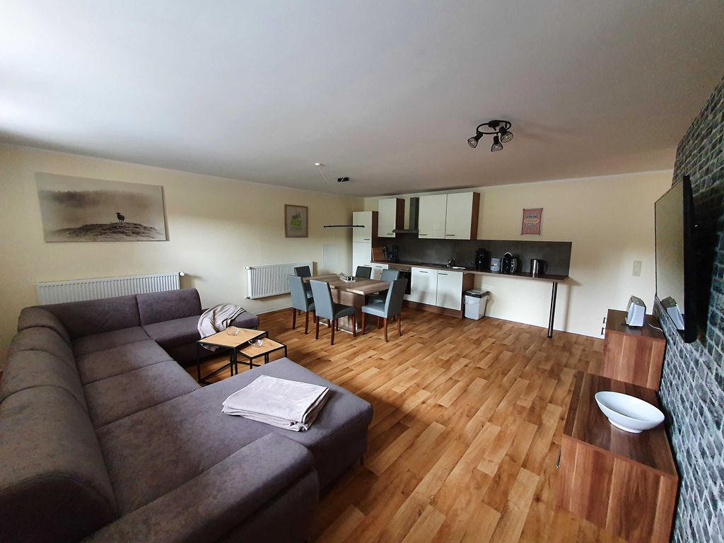 Offenes Wohnzimmer mit Einbauküche und Esstisch