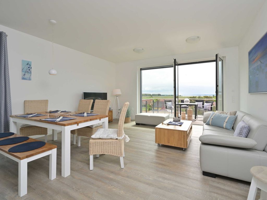 Haus Bodden-Markt Glowe: heller Wohn- und Essbereich mit bodentiefen Fenstern zum Balkon