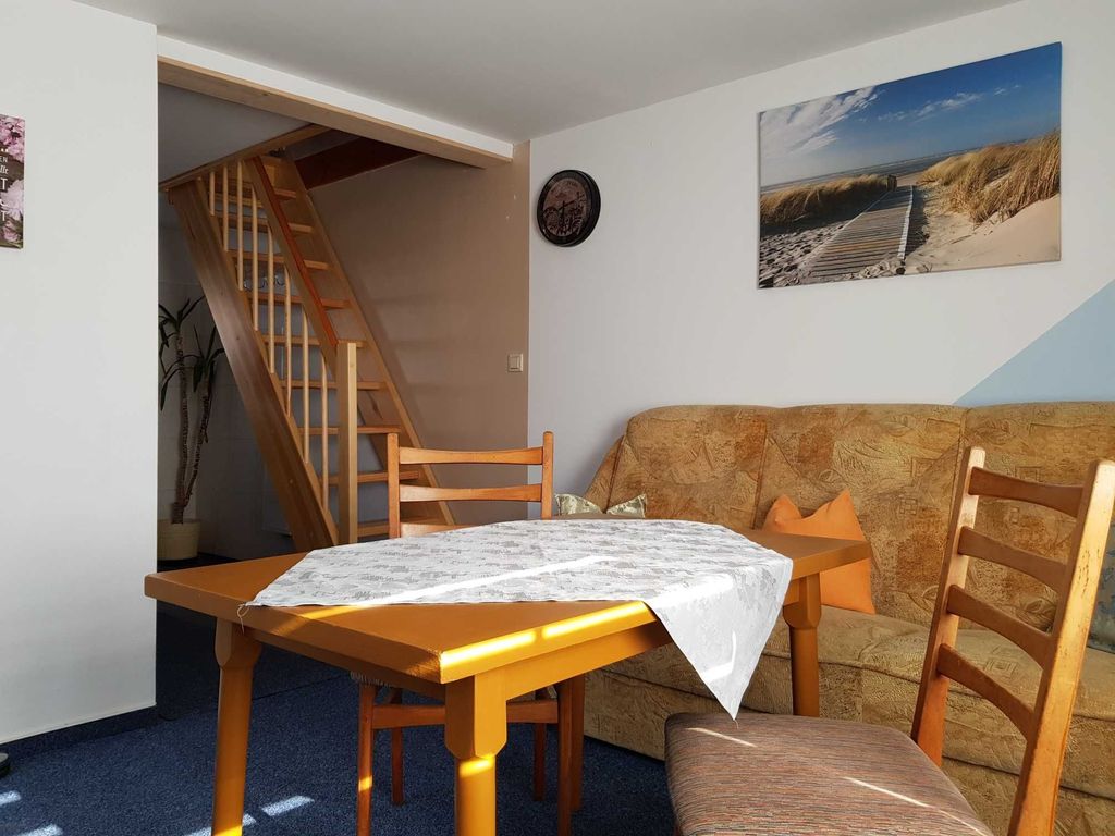 Offener Wohnbereich mit Esstisch und Blick auf Treppenaufgang ins OG