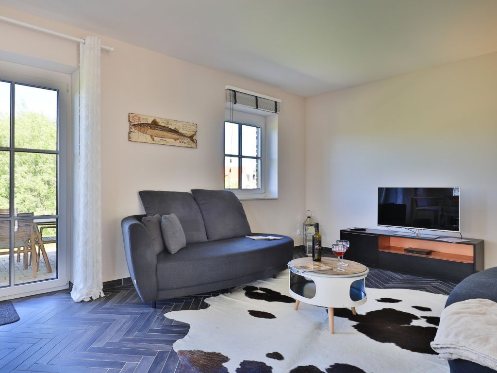 Jolle Ferienhaus - Blick auf den offenen Wohnbereich mit Zugang auf die Terrasse