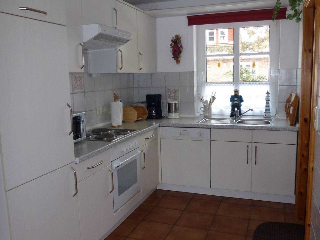 In der geräumigen und großzügig ausgestatteten Küche macht das Kochen auch im Urlaub Spaß! Töpfe und Pfannen, Geschirr, Gläser und Bestecke sowie weiteres Küchenzubehör sind in großer Anzahl vorhanden. Frühaufsteher erleben am Küchenfenster den Sonnenaufgang und haben einen wunderbaren Blick auf das benachbarte mit Reet gedeckte Friesenhaus.