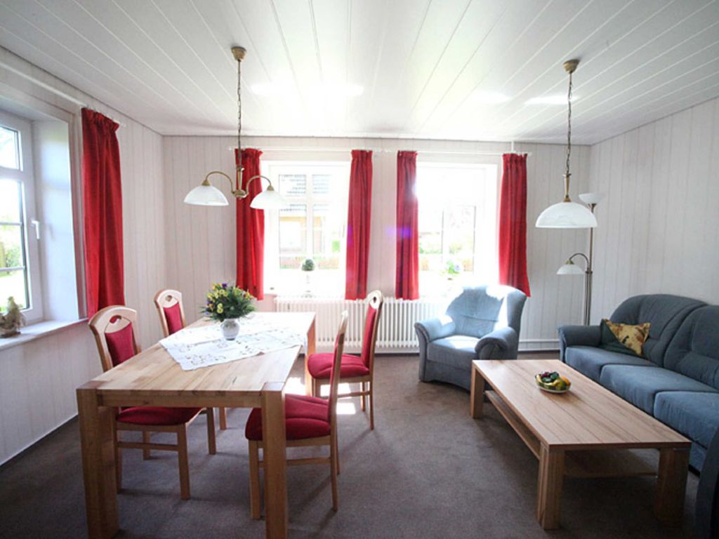 Das Wohnzimmer ist hell und freundlich mit Sat-TV,  gemütlicher Couchecke und großem Esstisch eingerichtet.