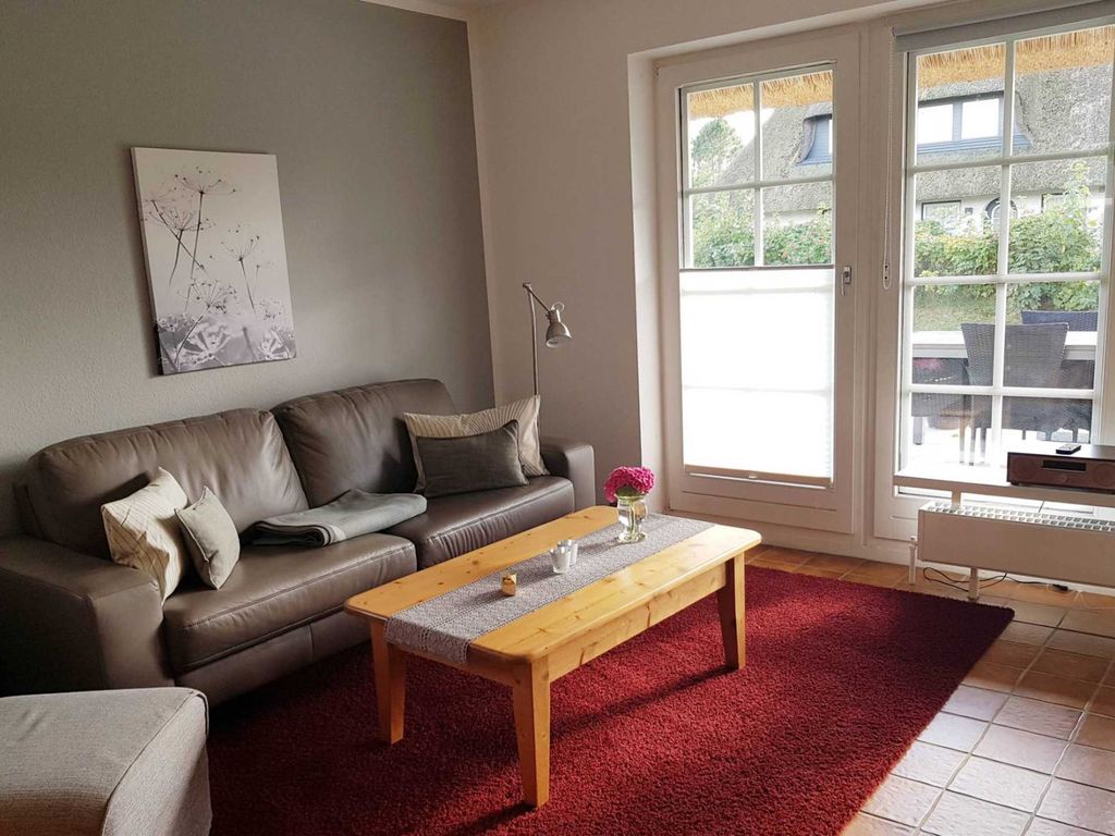 Wohnzimmer mit direktem Zugang zur Terrasse und anliegendem Garten
