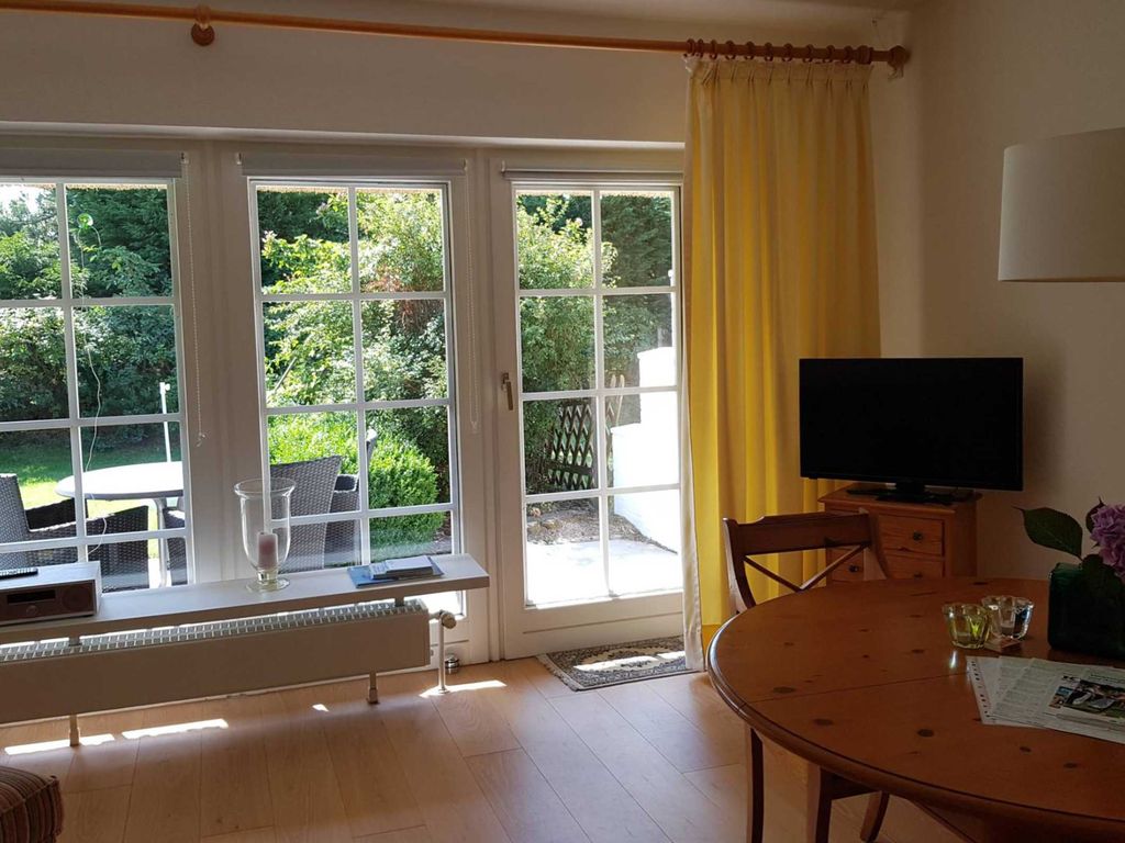 Wohnzimmer mit direktem Zugang zur Tarrasse und anliegendem Garten