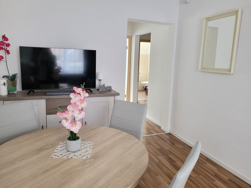 Wohnzimmer mit Esstisch und TV