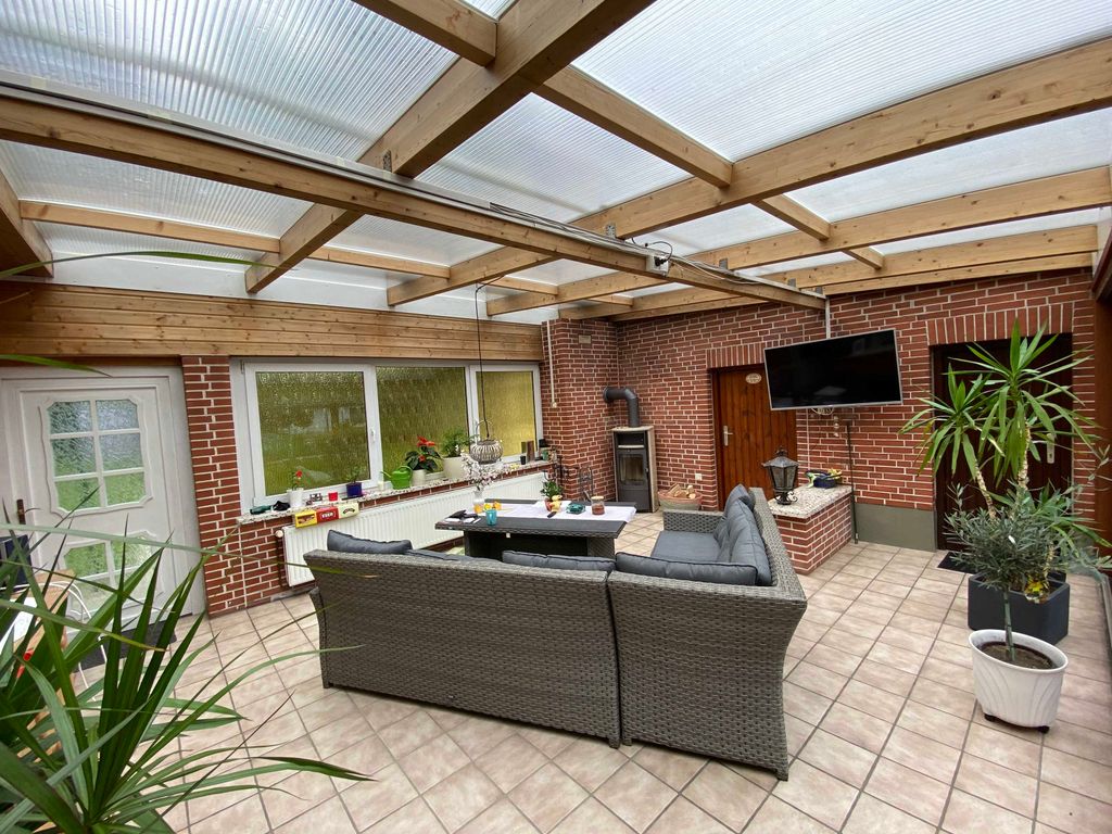 Möblierter Wintergarten mit Flachbild-TV und Kamin