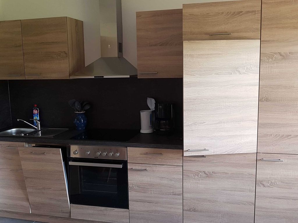 Küche mit Elektroherd, Kühlschrank und Spülmaschine