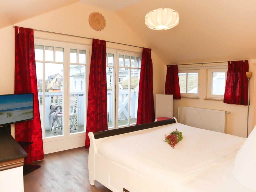 Das 1. Schlafzimmer mit Doppelbett, Flachbild-TV und Zugang zum möblierten Balkon