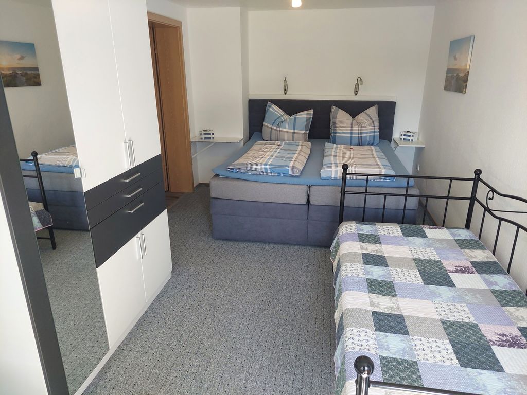 Der Schlafraum mit Doppelbett und Einzelbett sowie einem großen Kleiderschrank