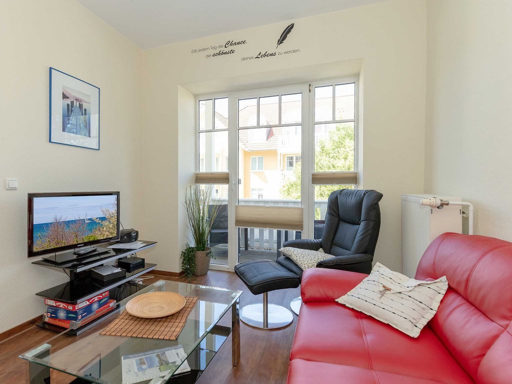 Der Wohnbereich mit Couchgarnitur, Flachbild-TV und Zugang zur West-Terrasse