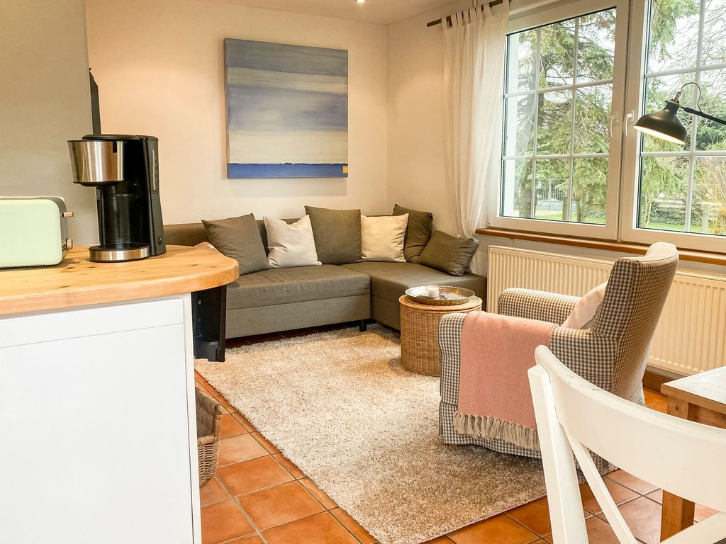 Wohnzimmer mit Schlafcouch und Sessel