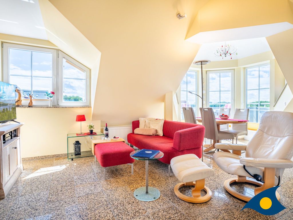 Wohnbereich mit offener Küche und Zugang zu einem Balkon