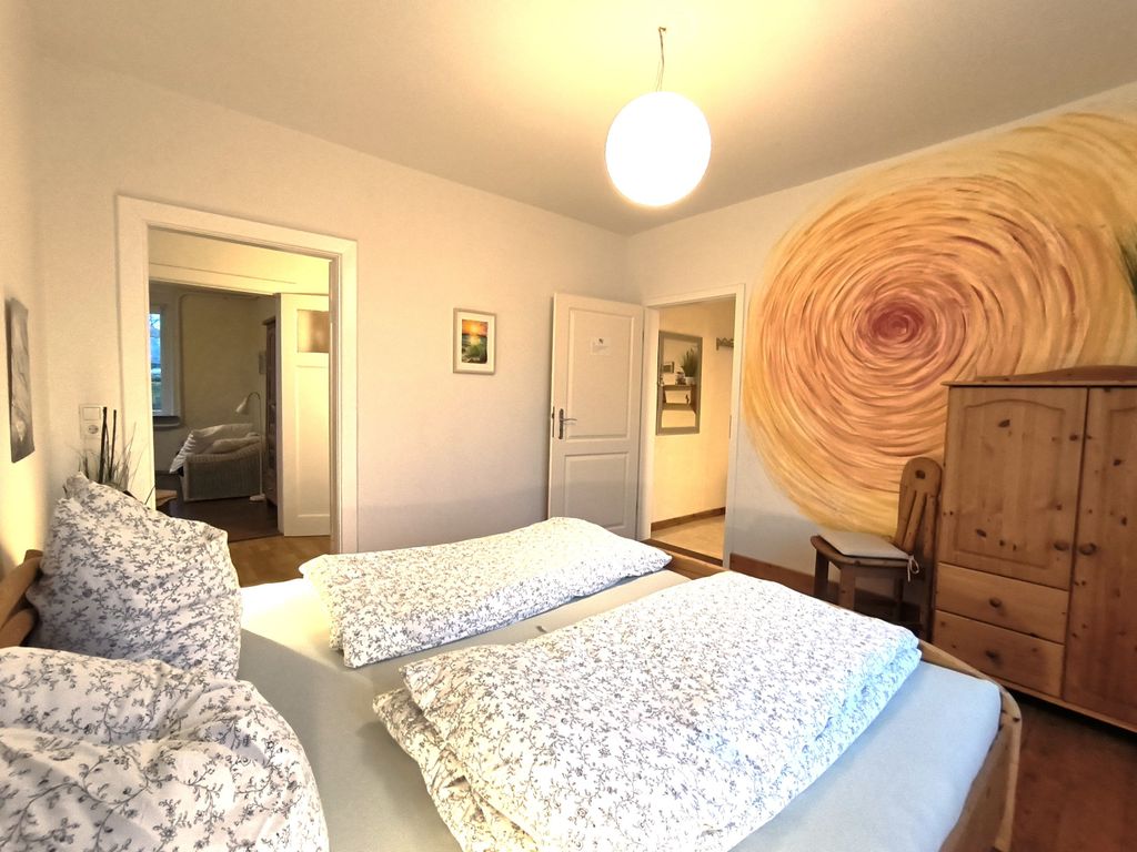Schlafzimmer mit Doppelbett und anliegendem Bad