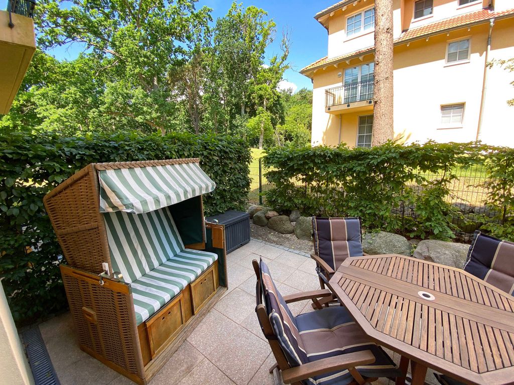 Grüne Düne Baabe – Gartenterrasse mit Strandkorb und Holzmöbeln vor der Villa