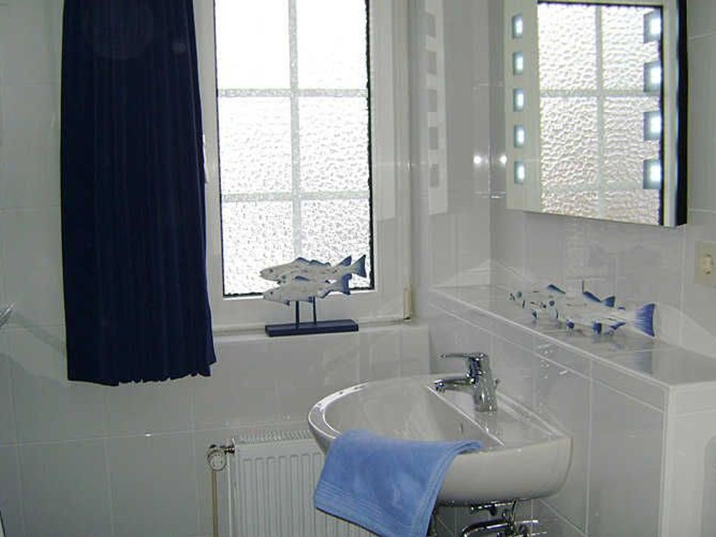 Das helle Badezimmer mit Dusche und WC ist mit viel Glas eingerichtet.