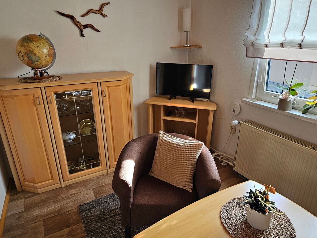 Kleines Wohnzimmer mit Couch und Flat-TV