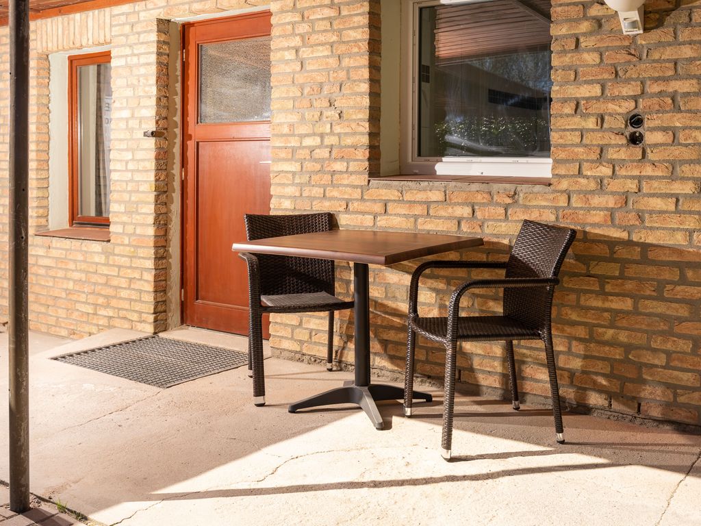 Vor jedem Zimmer ein Tisch mit Stühlen