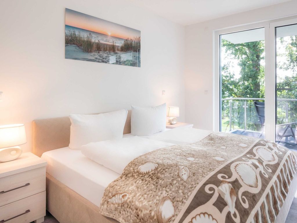 Haffresidenz Garz – Schlafzimmer mit Doppelbett und Tür zum Balkon