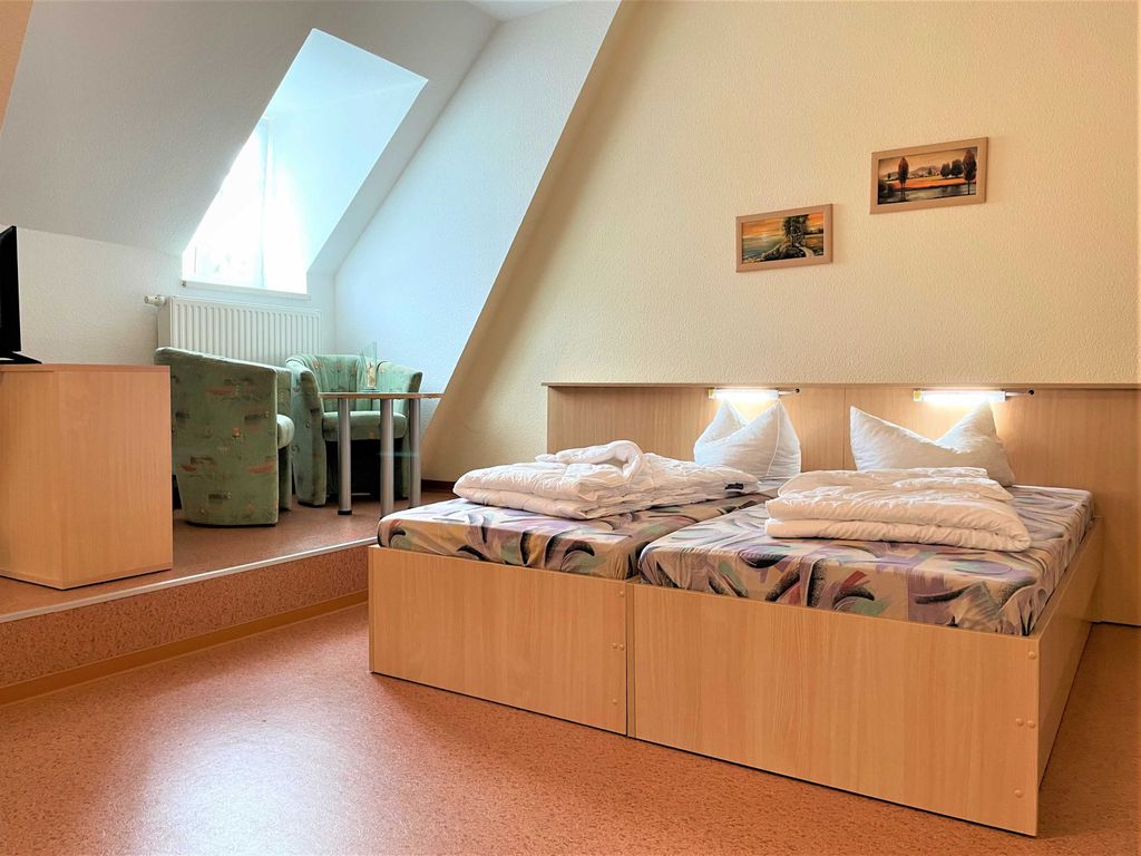 Doppelbett und Blick zur gemütlichen Sitzecke