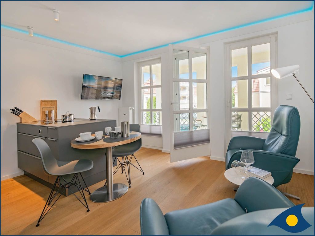 Wohnbereich mit offener moderner Küche und Zugang zum Balkon