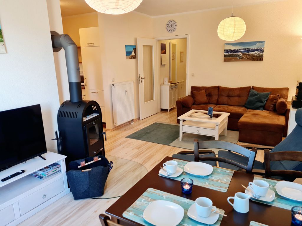 Wohnzimmer mit Kamin, Essecke und offener Küche