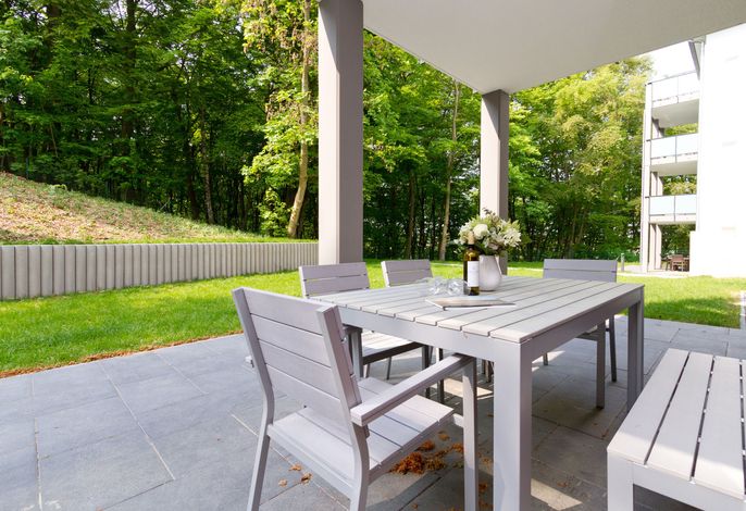 Residenzen am Kulm in Heringsdorf: überdachte Terrasse mit Rasenfläche am Waldrand