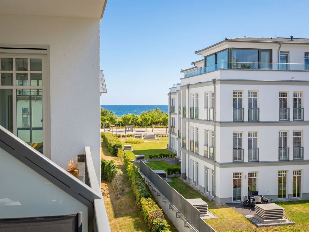 Westendpalais Ahlbeck – weißes Gebäude der Anlage mit Staffelgeschoss, Gartenanlage und Ostsee im Hintergrund