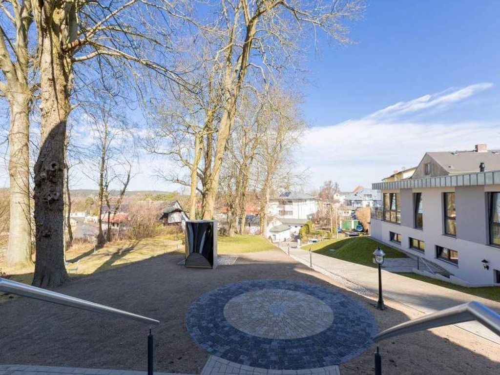 Villa Bellevue Heringsdorf – Außenanlage mit gepflastertem Rondell, altem Baumbestand und Gebäudeflügel