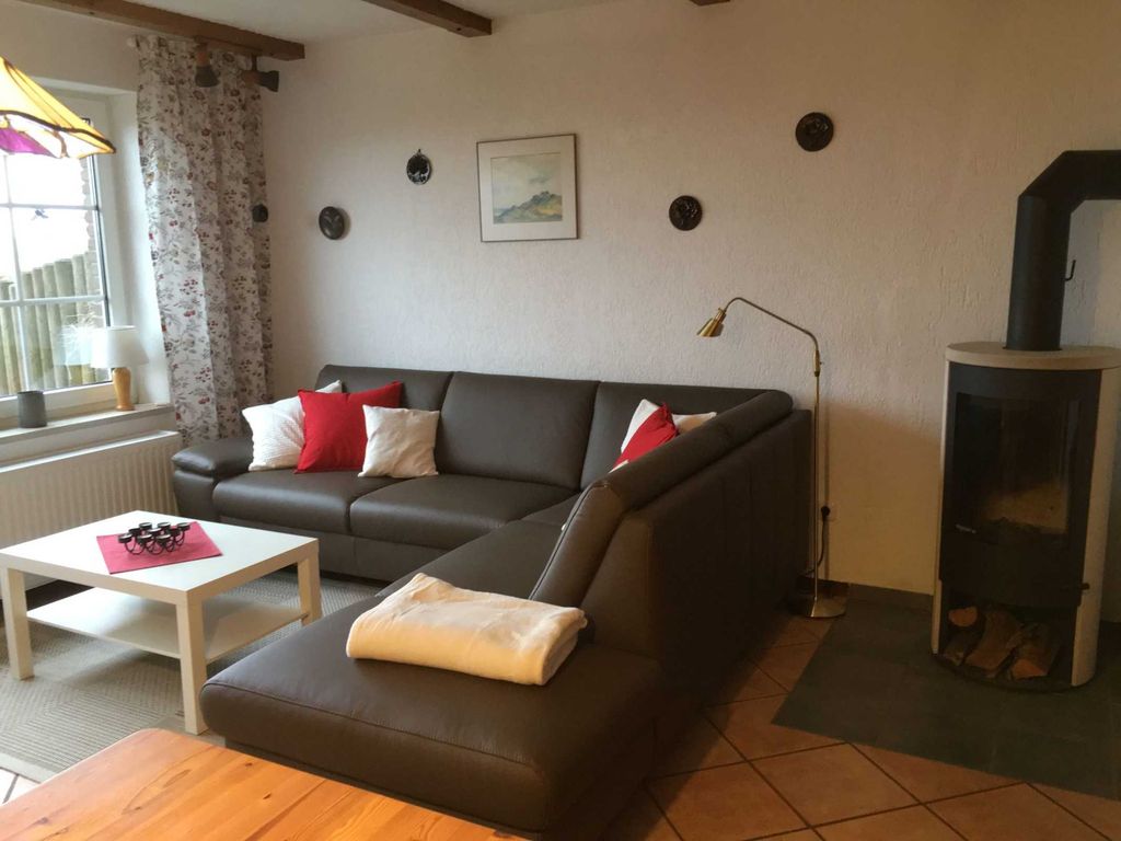 Wohnzimmer mit Terrassenzugang, Kamin und Küchenzeile