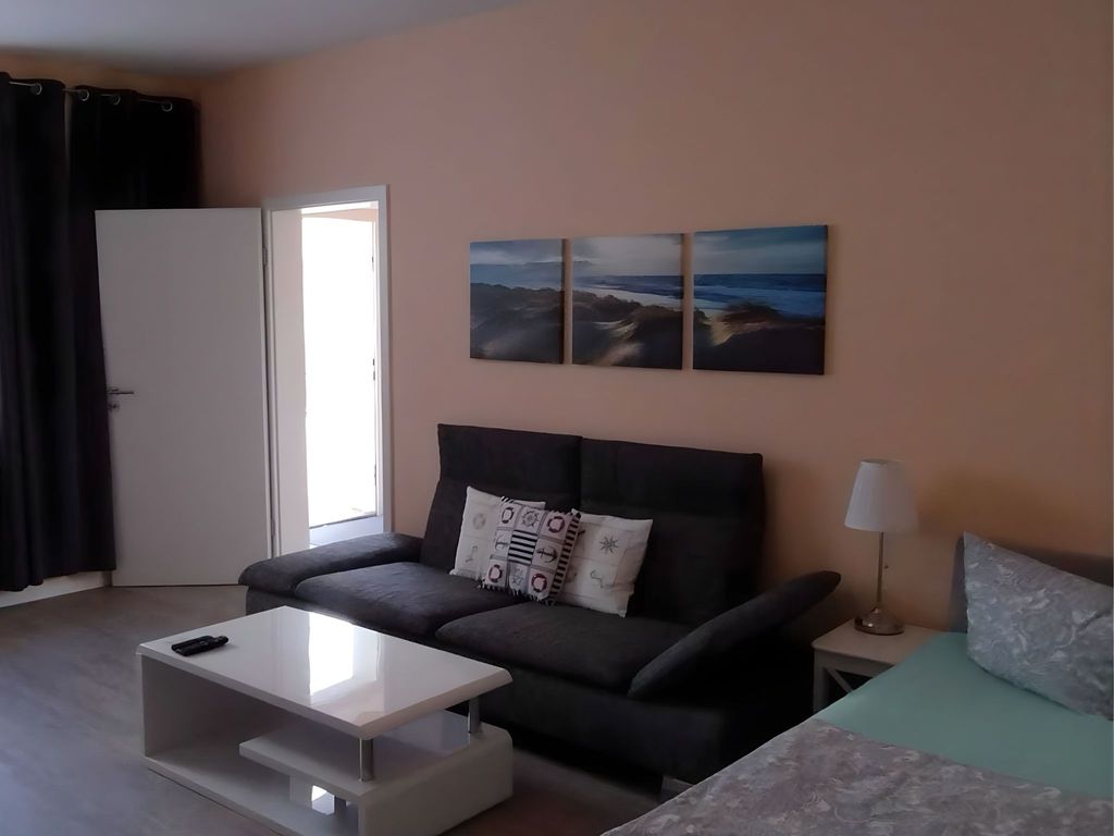 Wohnzimmer mit Schlafcouch und Bett