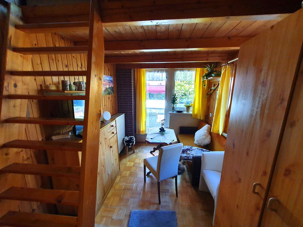 Blick ins Wohnzimmer mit Treppe zum Hochbett