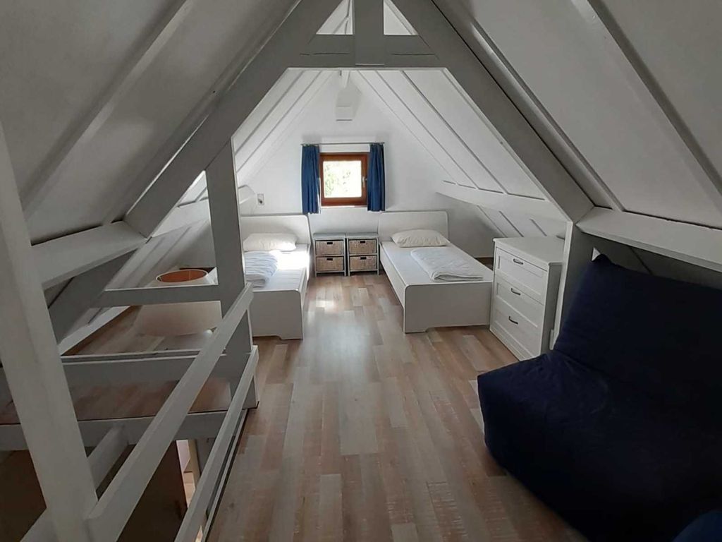 Schlafzimmer im Dachgeschoss mit zwei Einzelbetten und zwei zusätzlichen Schlafsesseln