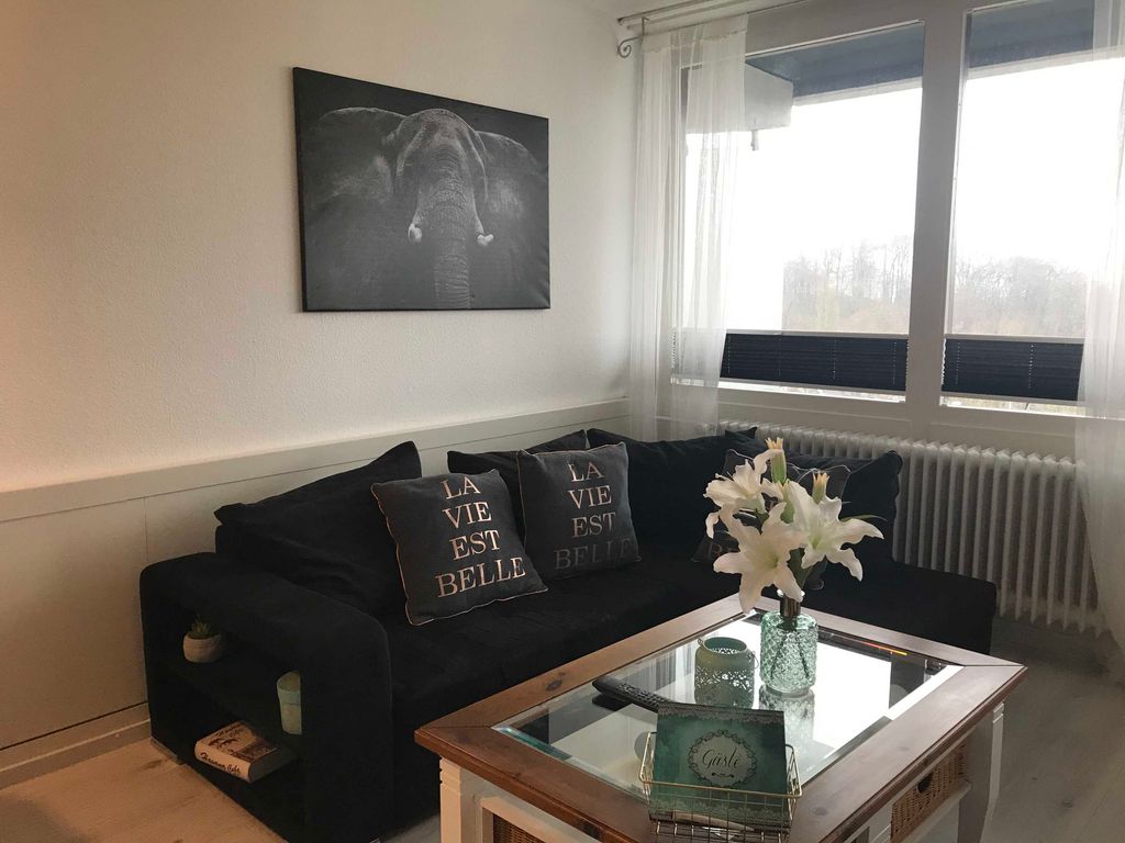 Wohn- Essbereich mit Schlafcouch und Zugang zum Balkon
