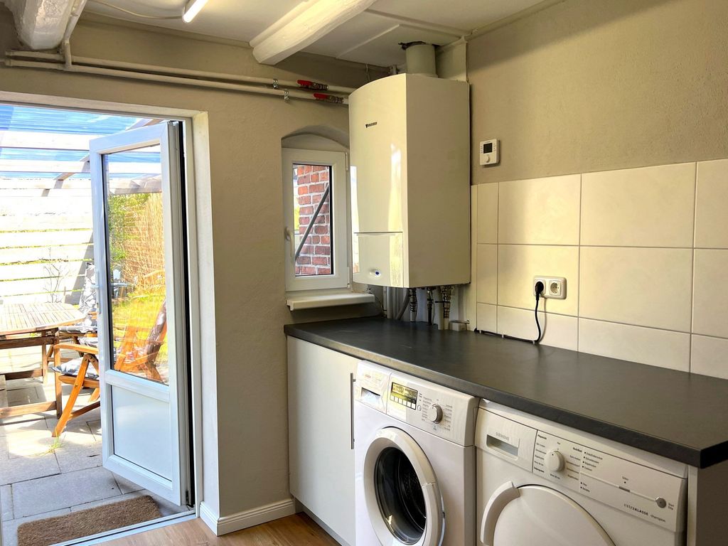 Hauswirtschaftsraum mit Waschmaschine und Trockner. Ausgang zur 2. Terrasse und hinterem Garten