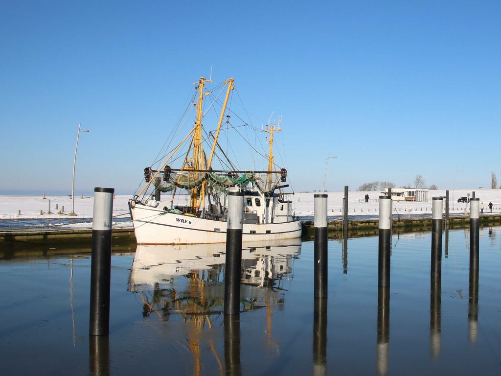 Einsamer Kutter im winterlichen Hafen