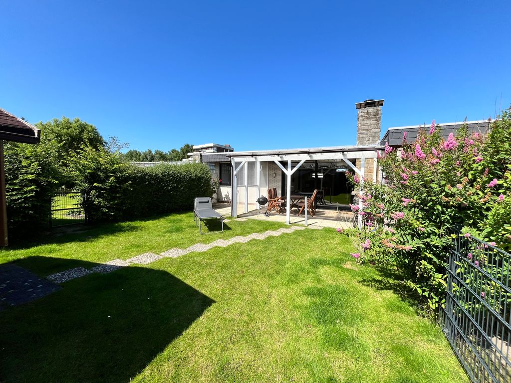 Gartenansicht mit windgeschützter und überdachter Terrasse, sowie Gartenmöbeln