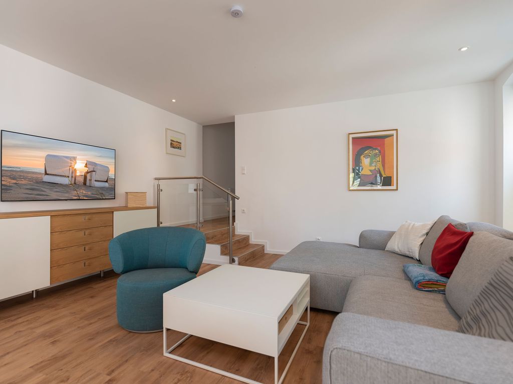 Offenes Wohnzimmer mit Sitzbereich und Treppe zum Obergeschoss