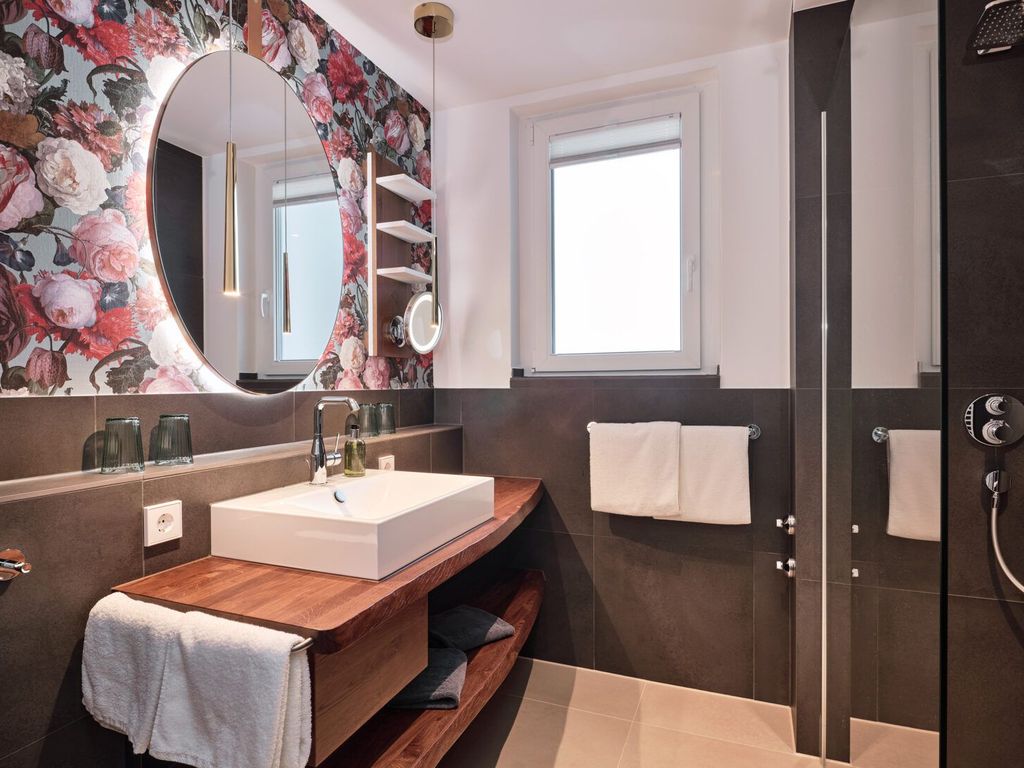 Tageslicht Bad mit Dusche und großem Waschbecken.