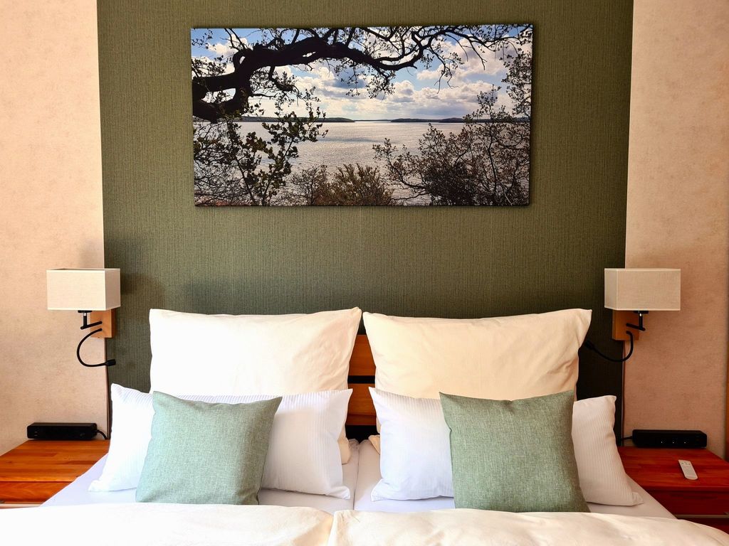 offenes Wohn-/Schlafzimmer mit einem bequemen Doppelbett in Komforthöhe