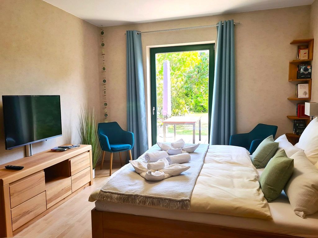 offenes Wohn-/Schlafzimmer mit einem bequemen Doppelbett in Komforthöhe