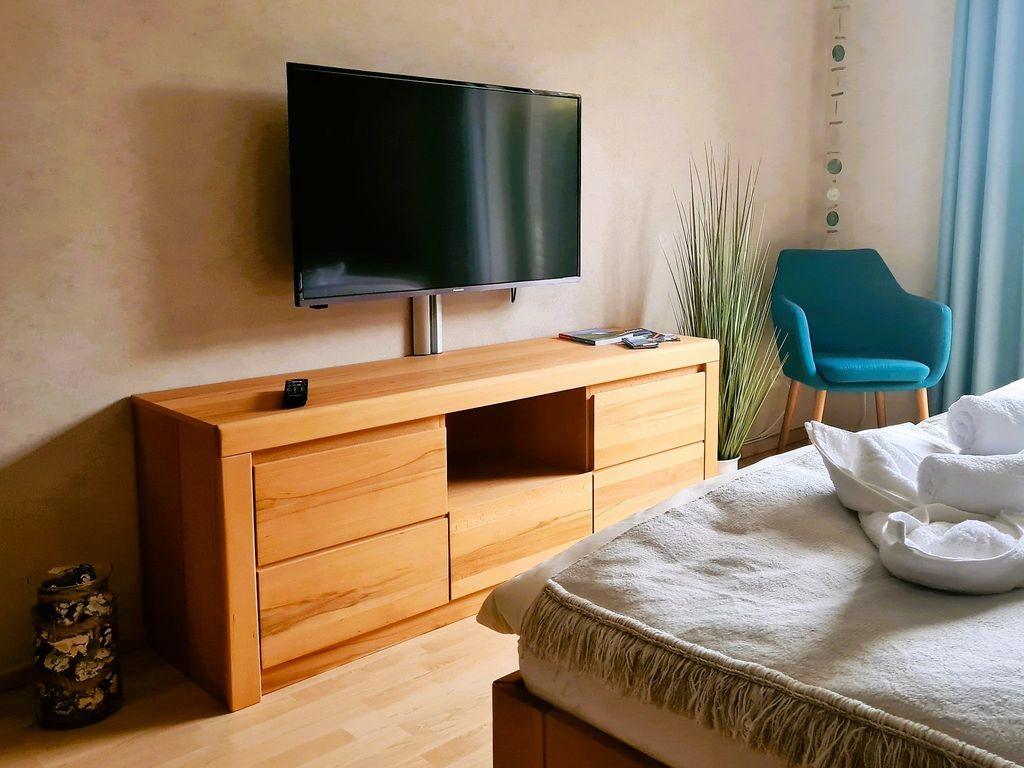 offenes Wohn-/Schlafzimmer mit einem bequemen Doppelbett in Komforthöhe